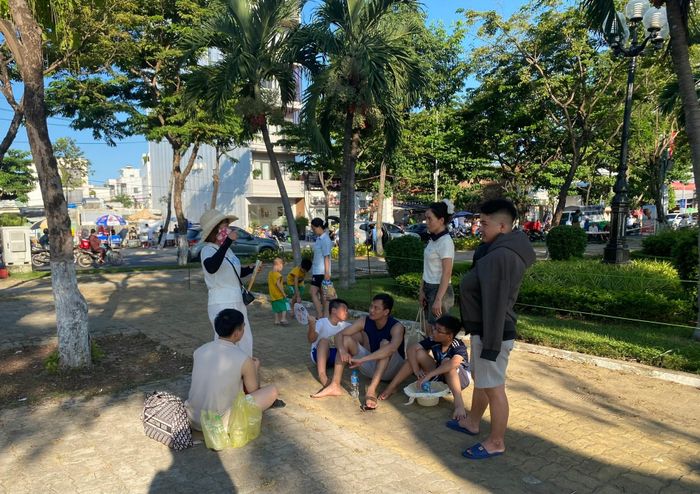 Nhiều gia đình có con nhỏ đã chọn những bóng mát để chờ xem pháo hoa. Ảnh: VĨNH LỘC