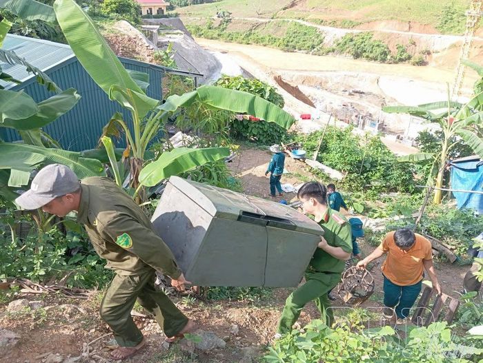 Chiến sĩ Công an xã Nậm Nèn hỗ trợ người dân vùng nguy cơ sạt lở di dời nhà cửa, tài sản đến nơi an toàn.