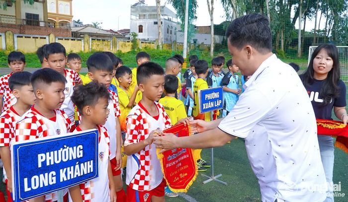 Ông Phạm Thái Thuận, Chánh Văn phòng Báo và Phát thanh, Truyền hình Đồng Nai tặng cờ lưu niệm cho các đội bóng. Ảnh: An Nhơn