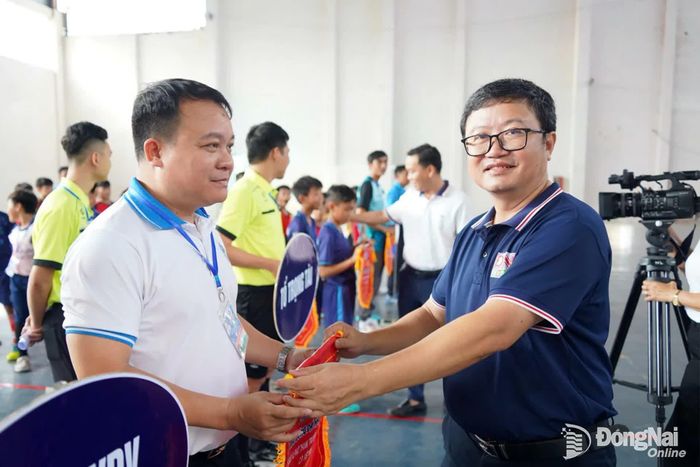 Trưởng phòng Thư ký biên tập Báo và Phát thanh, Truyền hình Đồng Nai Lâm Văn Phương trao cờ lưu niệm cho các đội bóng tham gia giải. Ảnh: Lê Duy