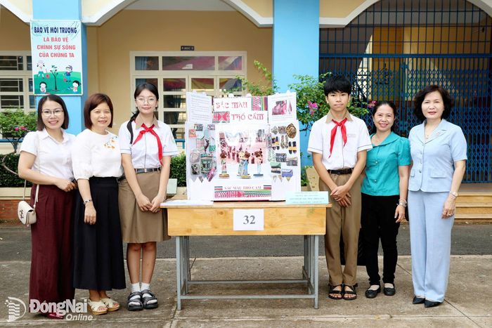 Bí thư Đảng ủy, Chủ tịch HĐND phường Xuân Lộc Nguyễn Thị Cát Tiên tham quan, chụp hình với nhóm tác giả sản phẩm, mô hình dự thi “Sắc màu thổ cẩm” của học sinh lớp 8/1, Trường THCS Trần Phú, phường Xuân Lộc. Ảnh: Tuệ Lâm