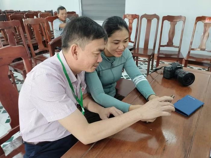  Cán bộ Phòng giao dịch Ngân hàng CSXH Phù Mỹ trao đổi với tổ trưởng tổ tiết kiệm và vay vốn thôn Thái An (xã An Lương) về việc nhận tiền gửi tiết kiệm của người dân qua ứng dụng quản lý tín dụng chính sách. Ảnh: T.S 