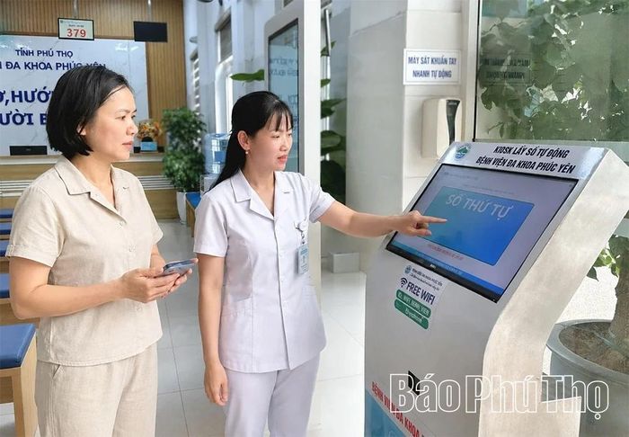 Hướng dẫn người dân lấy số thứ tự bằng máy tự động tại Bệnh viện Đa khoa Phúc Yên.
