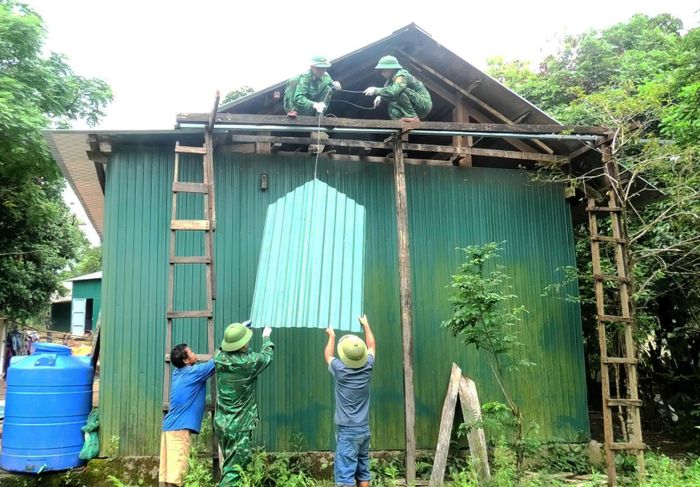 Cán bộ, chiến sĩ Đồn Biên phòng Cà Xèng giúp dân sửa chữa, làm nhà mới - Ảnh: T.L