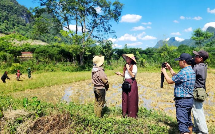 Chị Dương Thị Thùy Linh cùng đồng nghiệp tác nghiệp bằng điện thoại - Ảnh: T.L