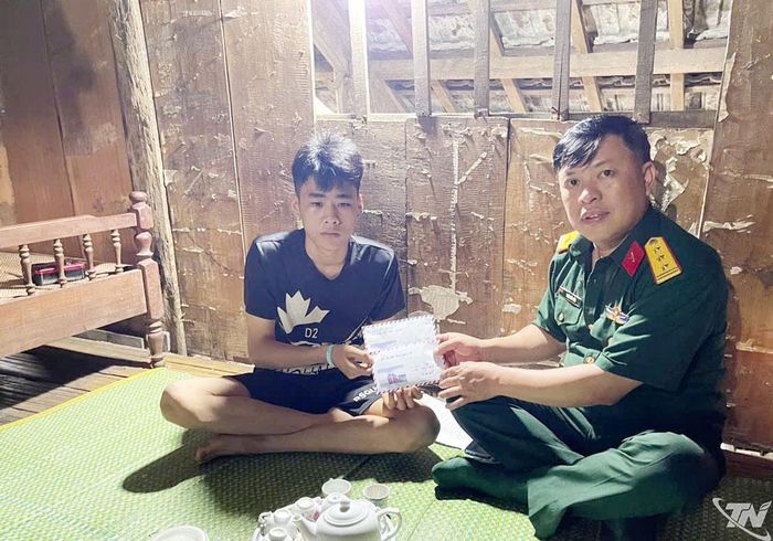 Đại diện Ban CHQS xã Nam Cường chuyển tiền hỗ trợ của Hội Phụ nữ Bộ CHQS tỉnh cho con đỡ đầu Nông Chiến Hạo.