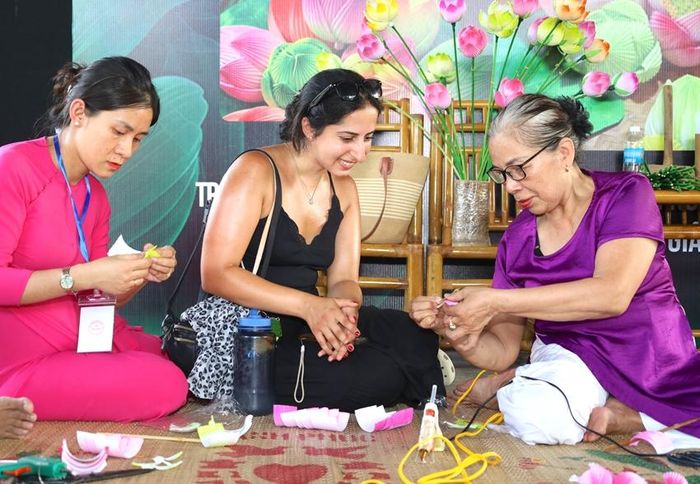  Khách nước ngoài chăm chú xem hướng dẫn làm hoa sen giấy Thanh Tiên