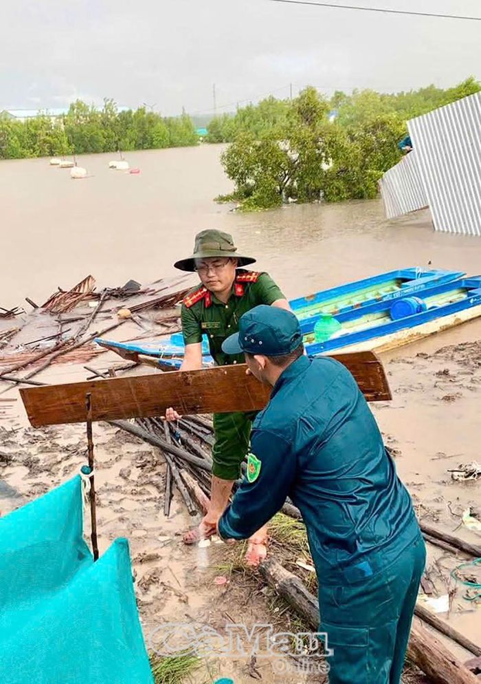 Lực lượng công an và dân quân thường trực xã hỗ trợ người dân thu gom tài sản sau vụ sạt lở đất.