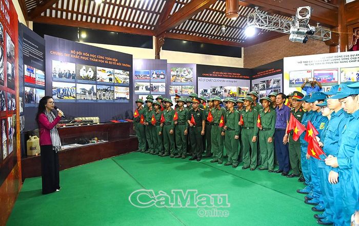 Cán bộ, chiến sĩ, dân quân tự vệ được hướng dẫn tham quan không gian trưng bày với nhiều hình ảnh, hiện vật phản ánh thảm họa da cam và hành trình khắc phục hậu quả chiến tranh hóa học.