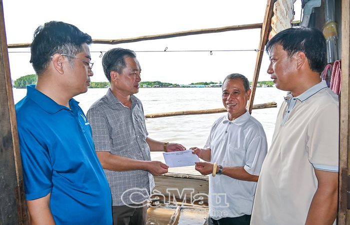 Ông Nguyễn Văn Khởi trao tiền hỗ trợ cho gia đình ông Phạm Văn Chiến.