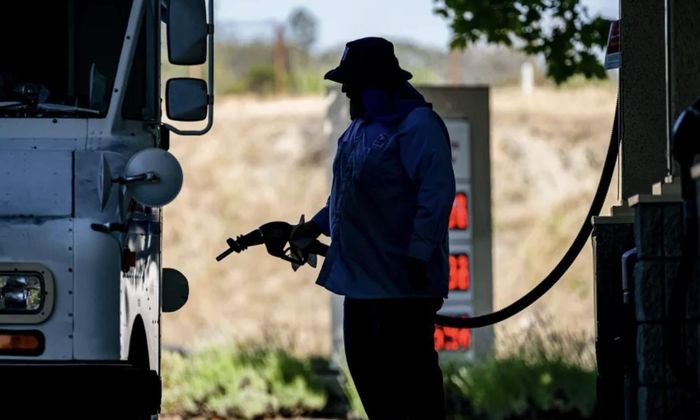 Một tài xế đang đổ xăng thường vào xe tại trạm xăng của hãng Shell ở Hercules, bang California (Mỹ) - Ảnh: Getty