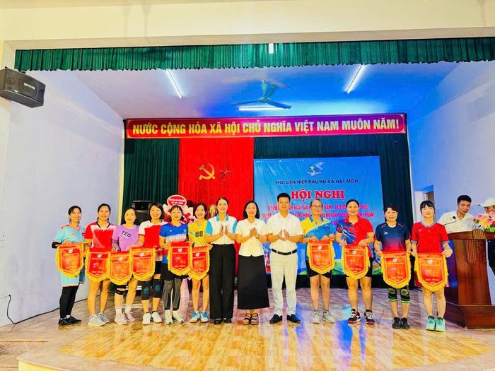 Lãnh đạo xã Hát Môn trao cờ lưu niệm cho các đội tham gia thi đấu giải bóng chuyền hơi nữ. Ảnh: MP