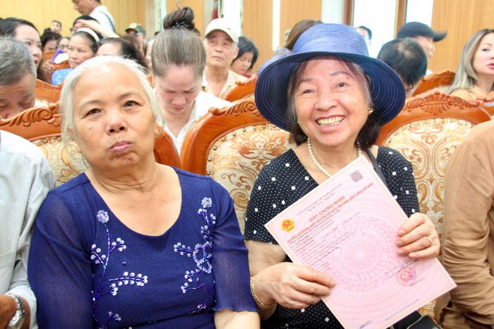 Người dân phấn khởi khi được trao Giấy chứng nhận quyền sử dụng đất. Ảnh: Cao Kỳ
