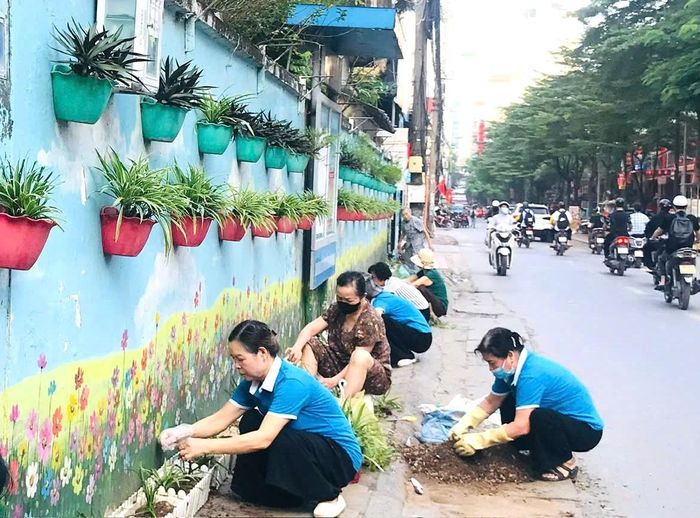 Hội Liên hiệp Phụ nữ phường Thanh Liệt tổng vệ sinh môi trường tại “Đoạn đường hoa do phụ nữ tự quản” dài 500m tại khu vực Công viên Chu Văn An. Ảnh: PV