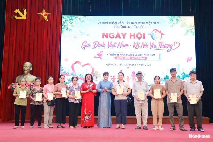 Lãnh đạo Thành phố và phường Nghĩa Đô trao tặng sổ tiết kiệm cho các gia đình còn khó khăn. Ảnh: MT