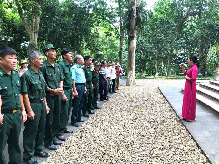 Đoàn đại biểu Hội Cựu chiến binh xã Phúc Sơn nghe giới thiệu về Khu Di tích K9 - Đá Chông. Ảnh: PV