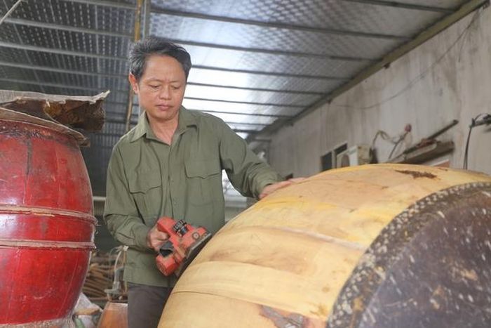 Ông Bùi Văn Nhượng đang hoàn thiện một cái trống để bàn giao cho khách hàng.