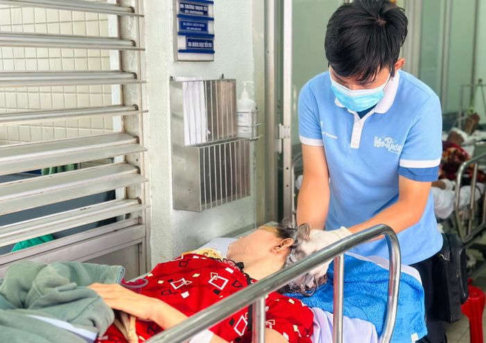  Tình nguyện viên gội đầu cho bệnh nhân ngay tại giường bệnh khoa Bộ môn Ngoại chấn thương chỉnh hình. Ảnh: THẢO PHƯƠNG 