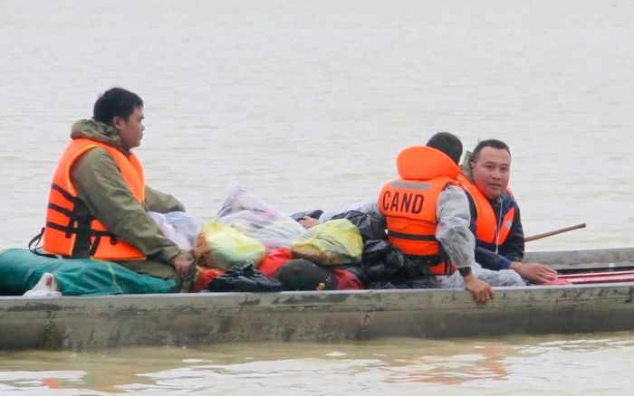 Phóng viên Tường Quân (ngoài cùng bên phải) lên ghe thuyền cùng lực lượng chức năng tiến sâu vào vùng lũ xã Hòa Thịnh, tỉnh Đắk Lắk