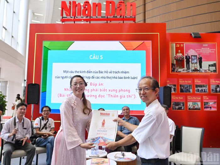 Độc giả nhận ấn phẩm đặc biệt của Báo Nhân Dân tại cuộc giao lưu.