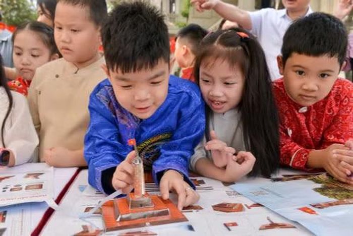 Các em học sinh tại triển lãm tương tác Cột cờ Hà Nội do Báo Nhân Dân tổ chức.