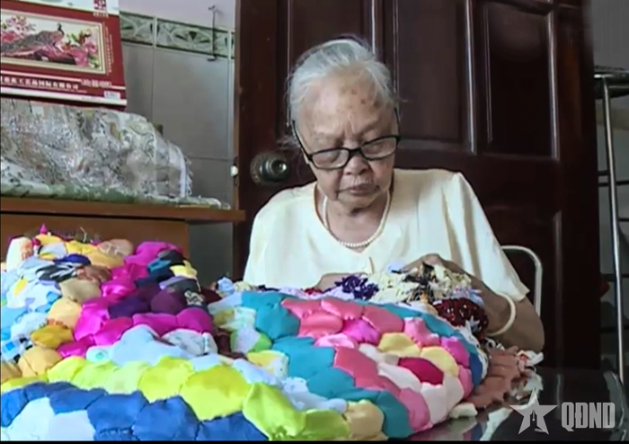  Hình ảnh mẹ Trần Kim Ngọc cặm cụi khâu chăn tặng những người có hoàn cảnh khó khăn. 