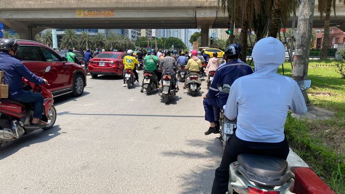 Người tham gia giao thông trú vào bóng râm khi dừng xe chờ đèn xanh tại một ngã tư ở vành đai 3 (Phạm Hùng - Dương Đình Nghệ, TP Hà Nội). Ảnh minh họa: PHÚC HẬU
