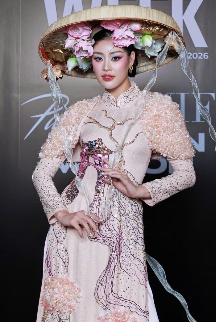 Hoa hậu Khánh Vân gây chú ý với áo dài cách tân mang cảm hứng dân gian. Điểm nhấn nằm ở chiếc nón lá cỡ lớn được trang trí hoa sen cùng các chi tiết đính kết thủ công trên thân trang phục.