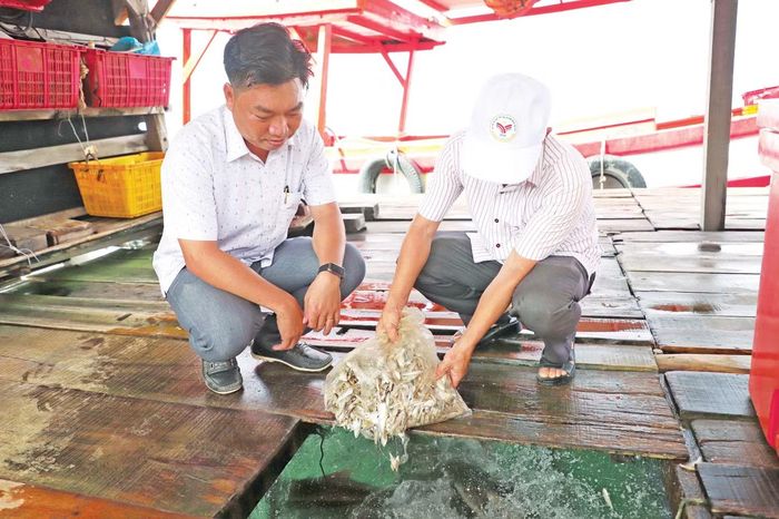 Ông Ngô Ngọc Chuẩn - Chủ tịch UBND xã Hòn Nghệ trao đổi với người dân về tình hình nuôi cá lồng bè