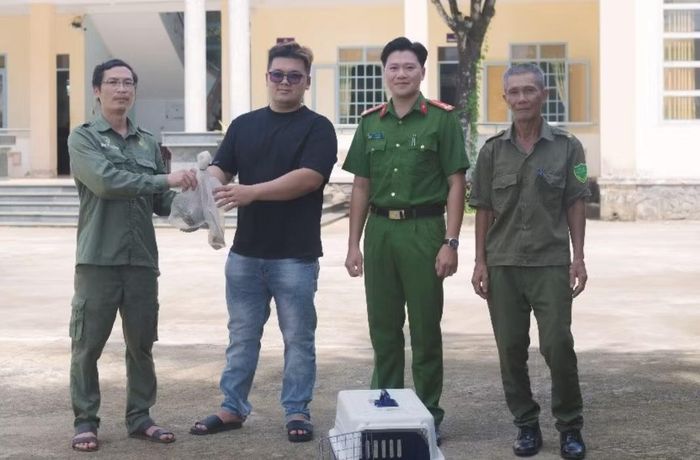 Anh Hào (áo đen) bàn giao cá thể kỳ đà vân quý hiếm cho lực lượng để chăm sóc, thả về tự nhiên.