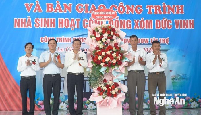 Đồng chí Thái Văn Thành - Ủy viên Ban Chấp hành Đảng bộ tỉnh, Phó Chủ tịch UBND tỉnh tặng hoa chúc mừng lãnh đạo địa phương và xóm Đức Vinh. Ảnh: Mai Giang