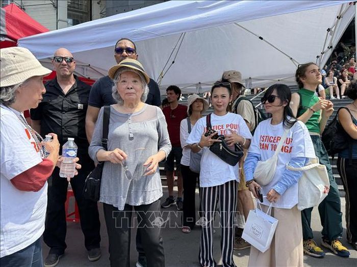 Bà Trần Tố Nga (giữa) - cựu phóng viên chiến trường của TTXVN và là nguyên đơn trong vụ kiện 14 công ty hóa chất mỹ tham dự cuộc tập trung kêu gọi công lý cho các nạn nhân chất độc da cam và chlordecone tại Quảng trường Bastille ở thủ đô Paris ngày 20/6/2026.