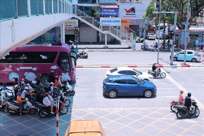 Người tham gia giao thông trên đường Trần Khát Chân dừng xe dưới bóng cầu vượt tránh ánh nắng gay gắt trong lúc chờ đèn tín hiệu giao thông.