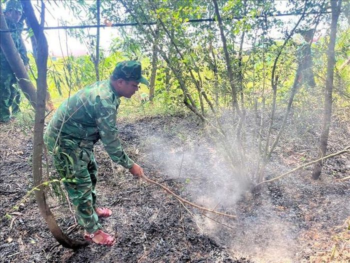 Lực lượng Bộ đội Biên phòng dập tắt tàn tro ngăn nguy cơ lửa bùng phát trở lại tại khu vực rừng thuộc xã Kim Ngân, Quảng Trị. Ảnh: TTXVN phát