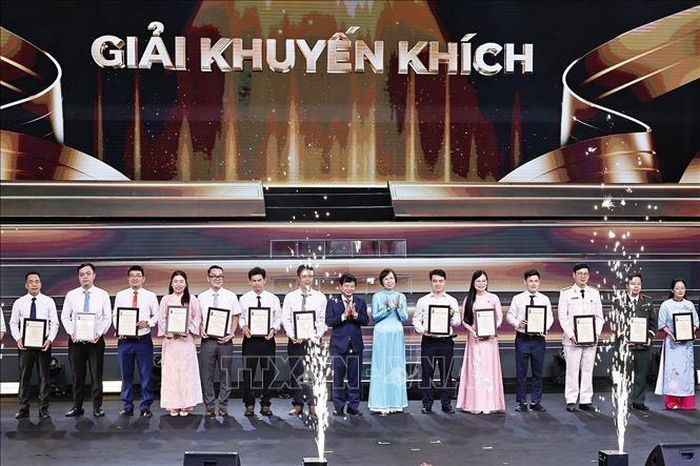 Tổng Giám đốc Thông tấn xã Việt Nam Vũ Việt Trang trao Giải Khuyến khích cho tác giả, nhóm tác giả. Ảnh: Doãn Tấn - TTXVN