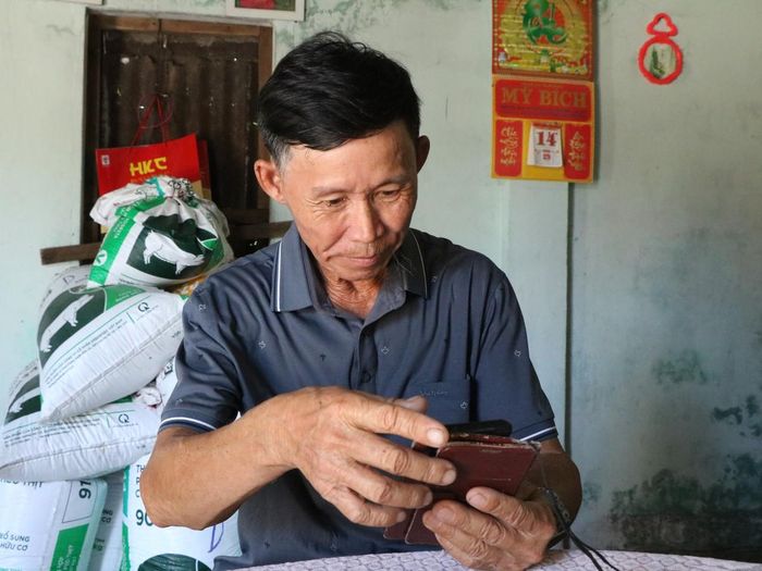 Chiếc điện thoại thông minh do con gái mua giúp ông Lâm kết nối với con cháu, xem tin tức dễ dàng hơn trong cuộc sống thường ngày.