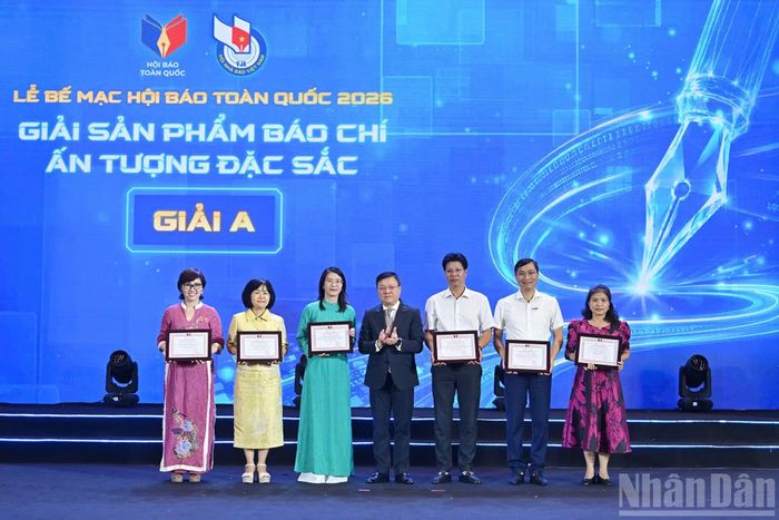 Đồng chí Lê Quốc Minh, Ủy viên Trung ương Đảng, Tổng Biên tập Báo Nhân Dân, Phó Trưởng Ban Tuyên giáo và Dân vận Trung ương, Chủ tịch Hội Nhà báo Việt Nam trao giải A Sản phẩm báo chí ấn tượng xuất sắc. Ảnh: Nhandan.