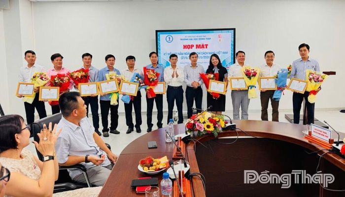 TS. Trương Tấn Đạt, Hiệu trưởng Trường Đại học Đồng Tháp (thứ 5 từ phải sang) và PGS-TS. Hồ Sỹ Thắng, Phó Hiệu trưởng Trường Đại học Đồng Tháp trao Giấy khen và tặng hoa cho các cá nhân. Ảnh: TÙNG THIỆN