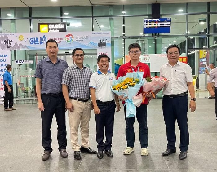  Đại diện Sở Giáo dục và Đào tạo tặng hoa chúc mừng em Nguyễn Vũ Mạnh Khang. Ảnh: Hồ Điểm 
