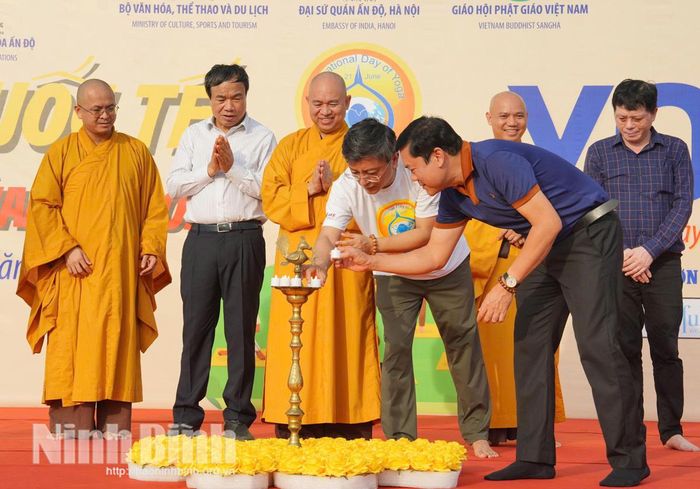 Các đại biểu thực hiện nghi thức thắp đèn truyền thống của Ấn Độ trong Ngày Quốc tế Yoga diễn ra tại chùa Tam Chúc.