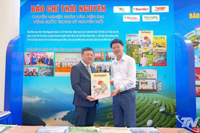Đồng chí Nguyễn Ngọc Sơn, Phó Giám đốc Báo và Phát thanh, Truyền hình Thái Nguyên, Phó Chủ tịch Hội Nhà báo tỉnh, trao tặng ấn phẩm đặc biệt cho đồng chí Lê Quốc Minh.