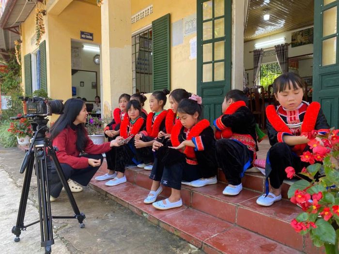 Phóng viên Ban Thị Ánh Nguyệt trò chuyện với các em dân tộc Dao Đỏ trước khi ghi hình.