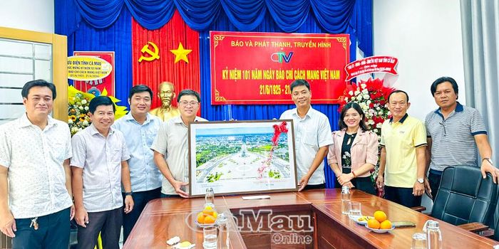Phó Giám đốc Báo và phát thanh, truyền hình Cà Mau Trương Văn Tuấn (bên phải) đón nhận món quà mừng 21/6 từ Phó Bí thư Đảng ủy, Chủ tịch UBND phường An Xuyên Huỳnh Văn Minh.