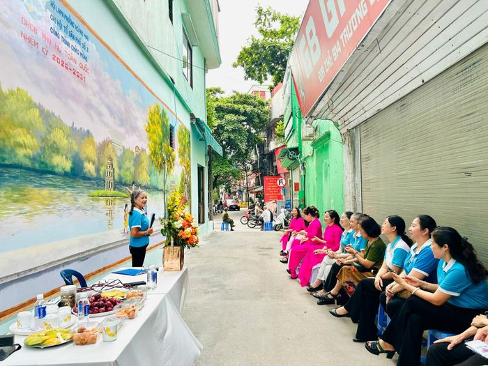 Bà Nguyễn Thị Tâm, Chi hội trưởng Chi hội Phụ nữ tổ dân phố 15, 16 Giáp Bát giới thiệu bức tranh tường tại ngõ 914 phố Trương Định. Ảnh: Trần Oanh