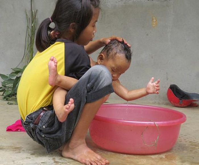 Hiền bế em gái theo bên mình trong những ngày tháng cơ cực. Khi ấy, cô bé mới 13 tuổi đã phải thay mẹ chăm sóc em nhỏ.