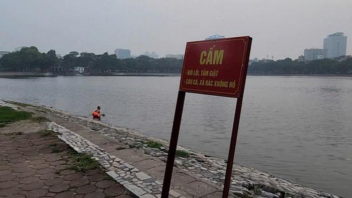 Người dân xuống hồ bơi dù có biển cấm. Ảnh: VA.