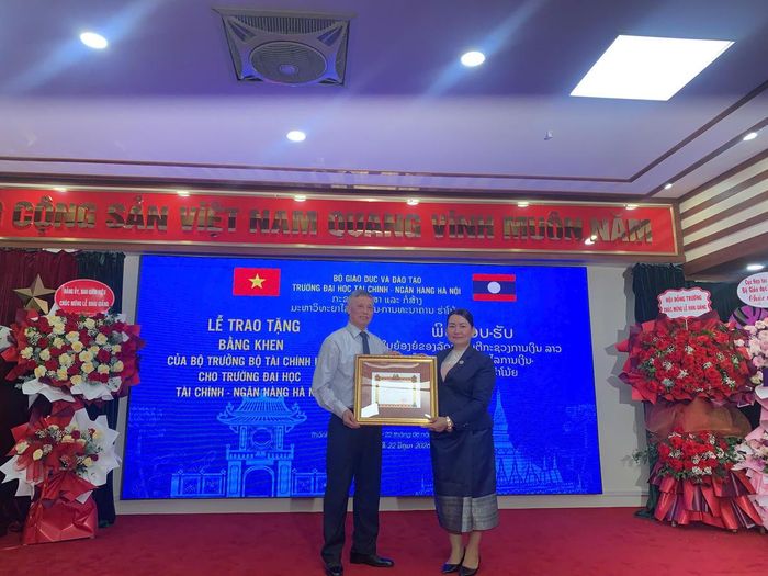 Thừa ủy quyền Bộ trưởng Bộ Tài chính nước CHDCND Lào, TS. Vongphachanh Vongpadith, Giám đốc Học viện Kinh tế - Tài chính cơ sở miền Bắc, trao Bằng khen của Bộ trưởng Bộ Tài chính Lào cho Trường Đại học Tài chính Ngân hàng Hà Nội.
