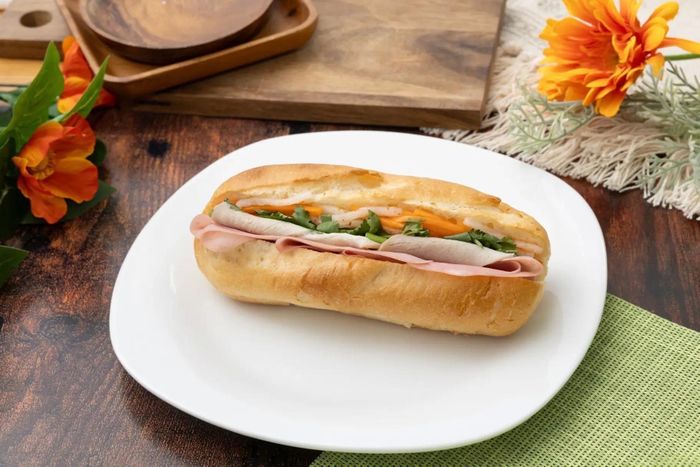 Bánh mì nhân heo quay, kết hợp rau củ ngâm chua và rau mùi.