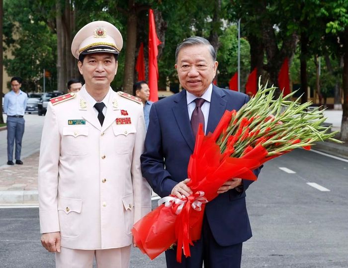 Trung tướng, PGS, TS Trịnh Ngọc Quyên, Giám đốc Học viện An ninh nhân dân tặng hoa chào đón Tổng Bí thư, Chủ tịch nước Tô Lâm tới dự buổi lễ. (Ảnh: TTXVN)