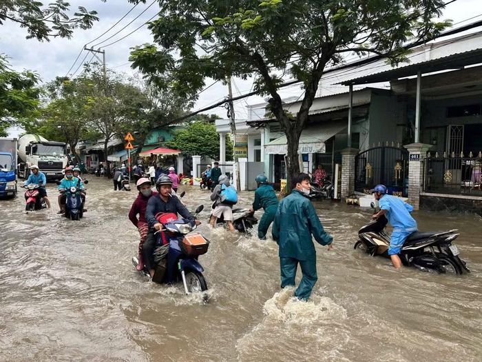 Người dân di chuyển qua một tuyến đường ngập.